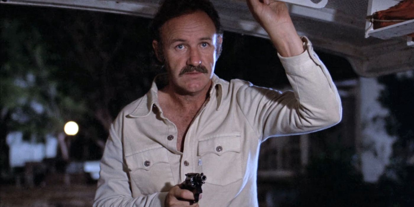 Harry Moseby (Gene Hackman) stands in the night aiming a revolver in &lsquo;Night Moves&rsquo; (1975).