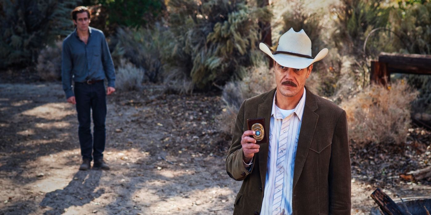 Bobby Andes stands in the forest with Edward Sheffield behind him in Nocturnal Animals 