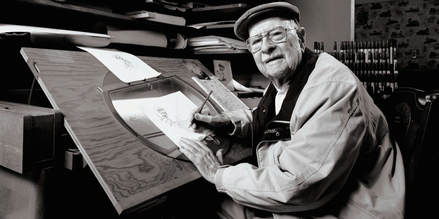 Ollie Johnson looking at the camera and smiling while sketching Mickey Mouse