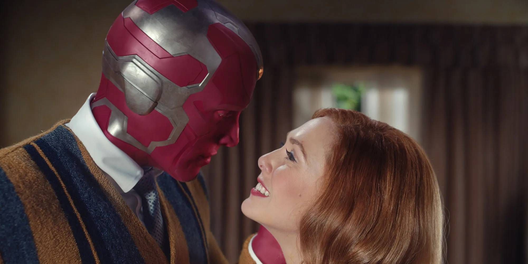 Paul Bettany as Vision looking at Elizabeth Olsen as Wanda, who is smiling, in Wandavision.