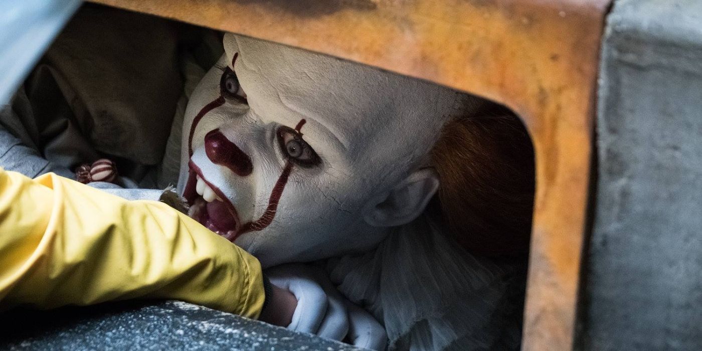 Bill Skarsgård as Pennywise the clown, biting Georgie&rsquo;s (Jackson Robert Scott) arm from the sewer in It