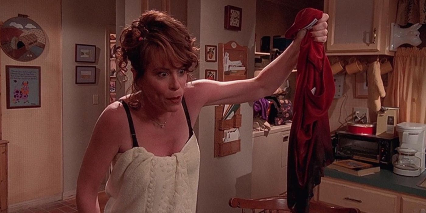 Lois angrily holds a sodden, burnt red dress