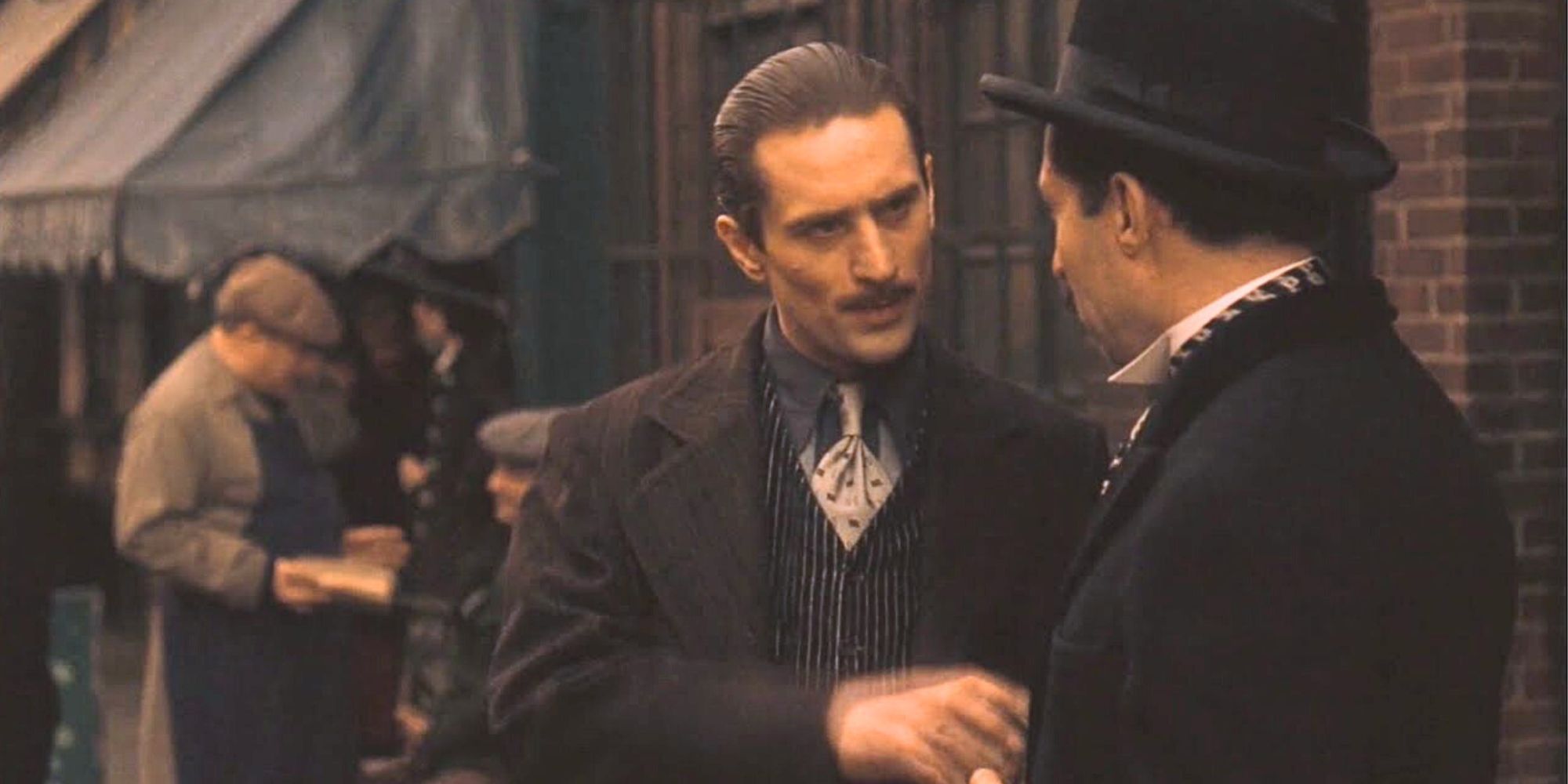 Robert De Niro speaking to a man in The Godfather: Part II (1974)