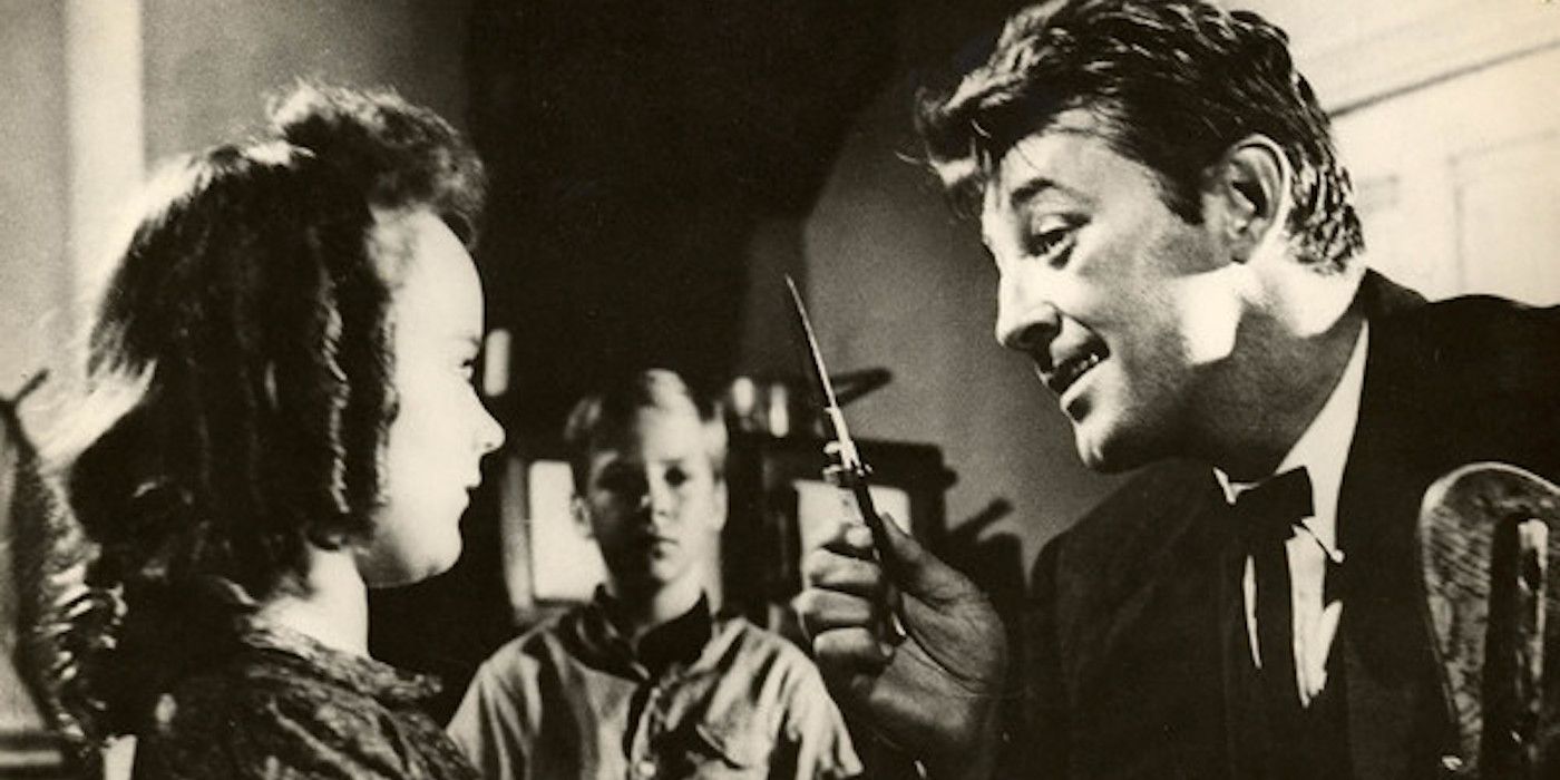 Robert Mitchum as Harry Powell, Billy Chapin as John Harper, and Sally Jane Bruce as Pearl Harper in The Night of the Hunter