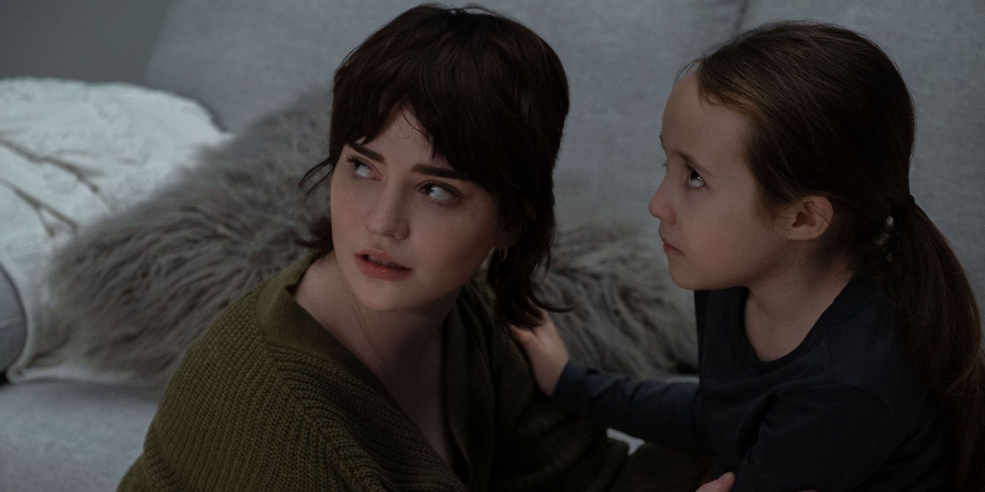 Sadie Harper (Sophie Thatcher) crouched and holding Sawyer Harper (Vivian Lyra Blair) in The Boogieman