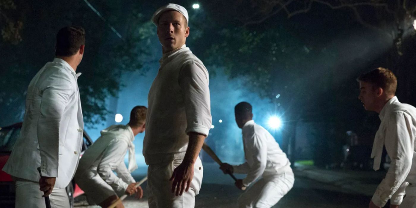 Glen Powell as Chad Radwell wearing all white and holding a baseball bat in 'Scream Queens'