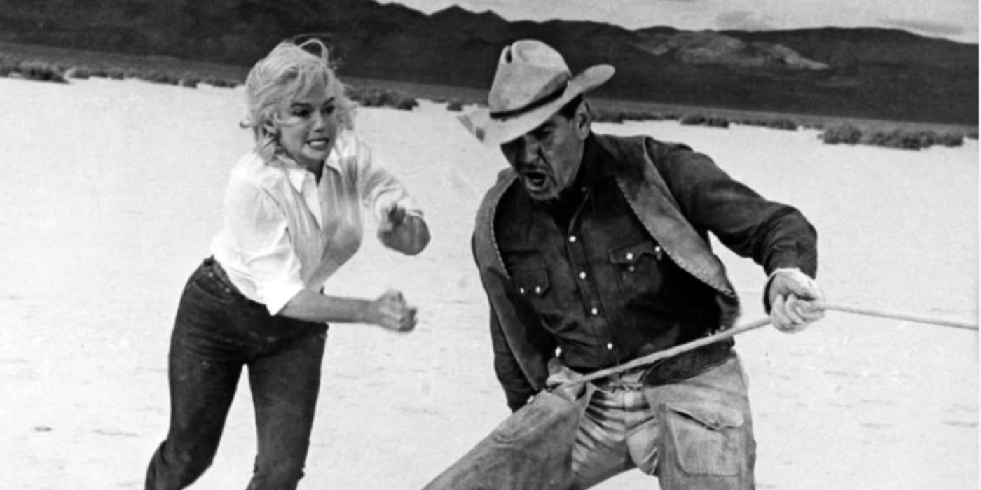 Marilyn Monroe and Clark Gable as Roslyn and Gaylord holding onto rope in 'The Misfits'