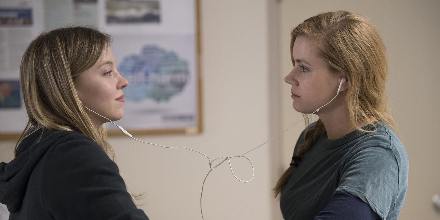 Alice shares her headphones with Camille with the two sharing a room in a psychiatric hospital in 'Sharp Objects' (2018)