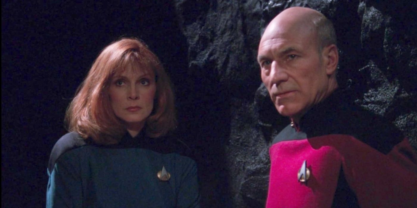 Dr. Crusher (Gates McFadden) and Captain Picard (Patrick Stewart) look seriously at someone offscreen while in a cave in Star Trek: The Next Generation episode, High Ground