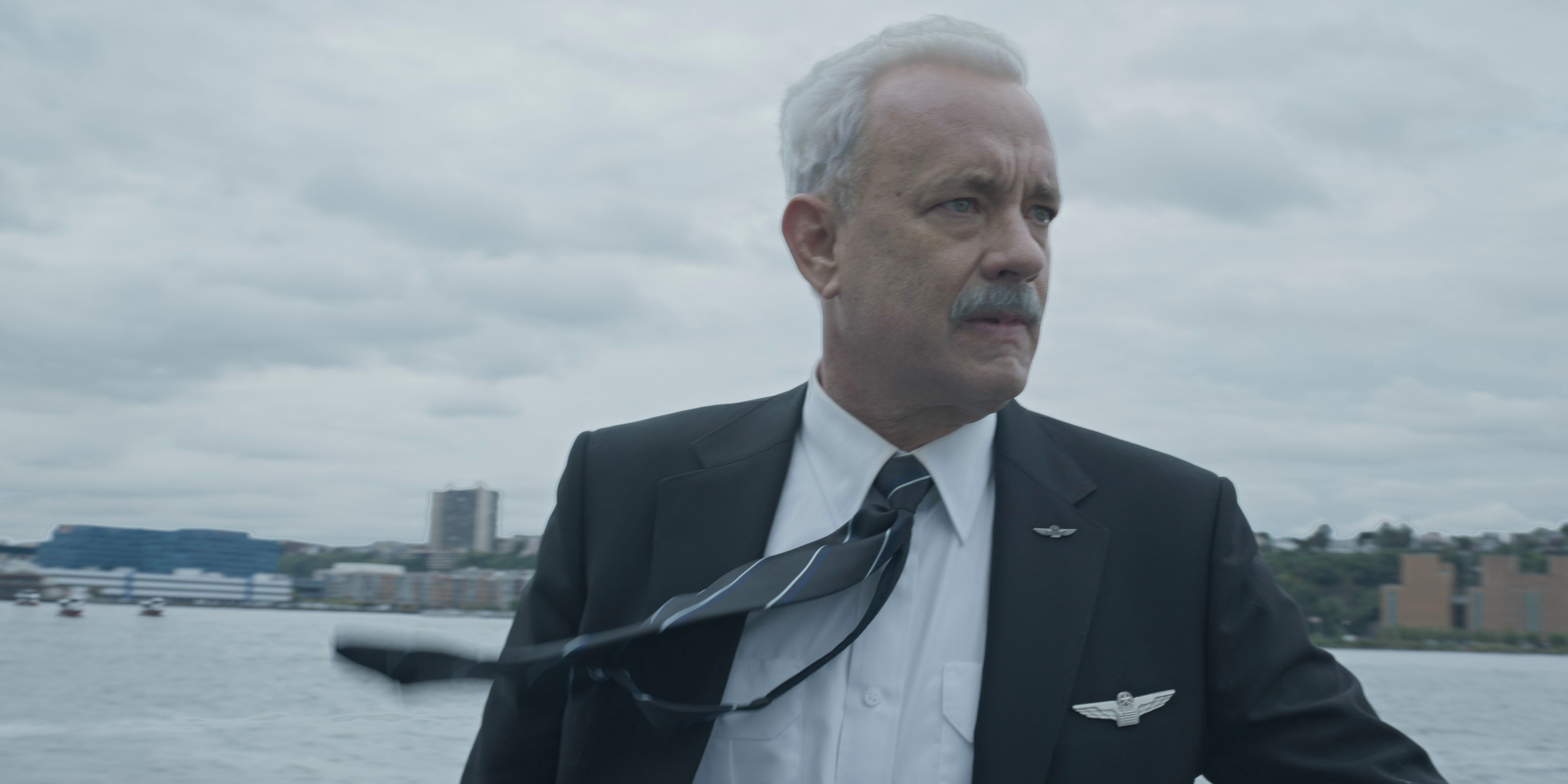 Sully (Tom Hanks) dramatically looking left with his tie blowing in the wind in Sully