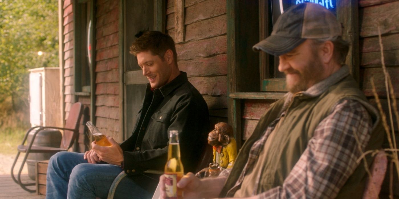 Dean Winchester (Jensen Ackles) and Bobby Singer (Jim Beaver) smiling and drinking beer in heaven in the Supernatural finale.