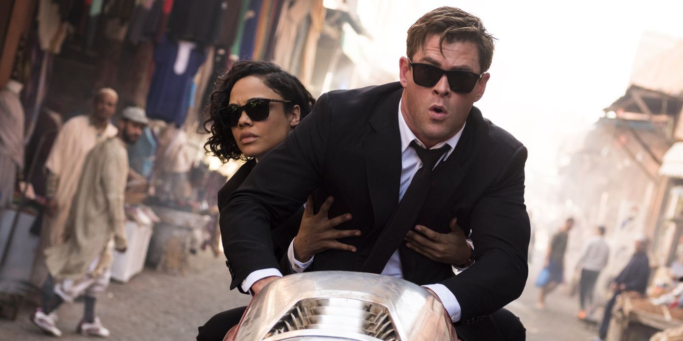 Agents M and H riding a bike across a city in Men in Black International