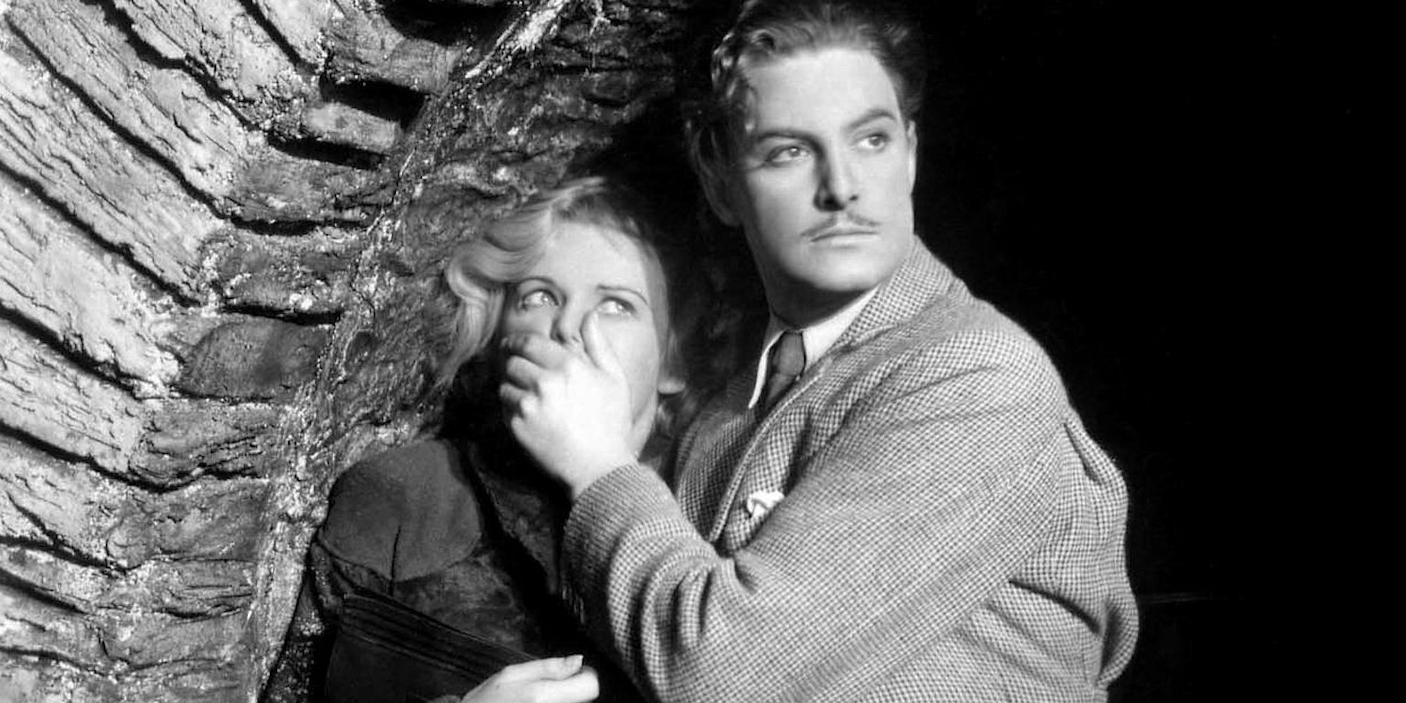 Hannay (Robert Donat) covering Pamela's (Madeline Carroll) mouth under a bridge in The 39 Steps