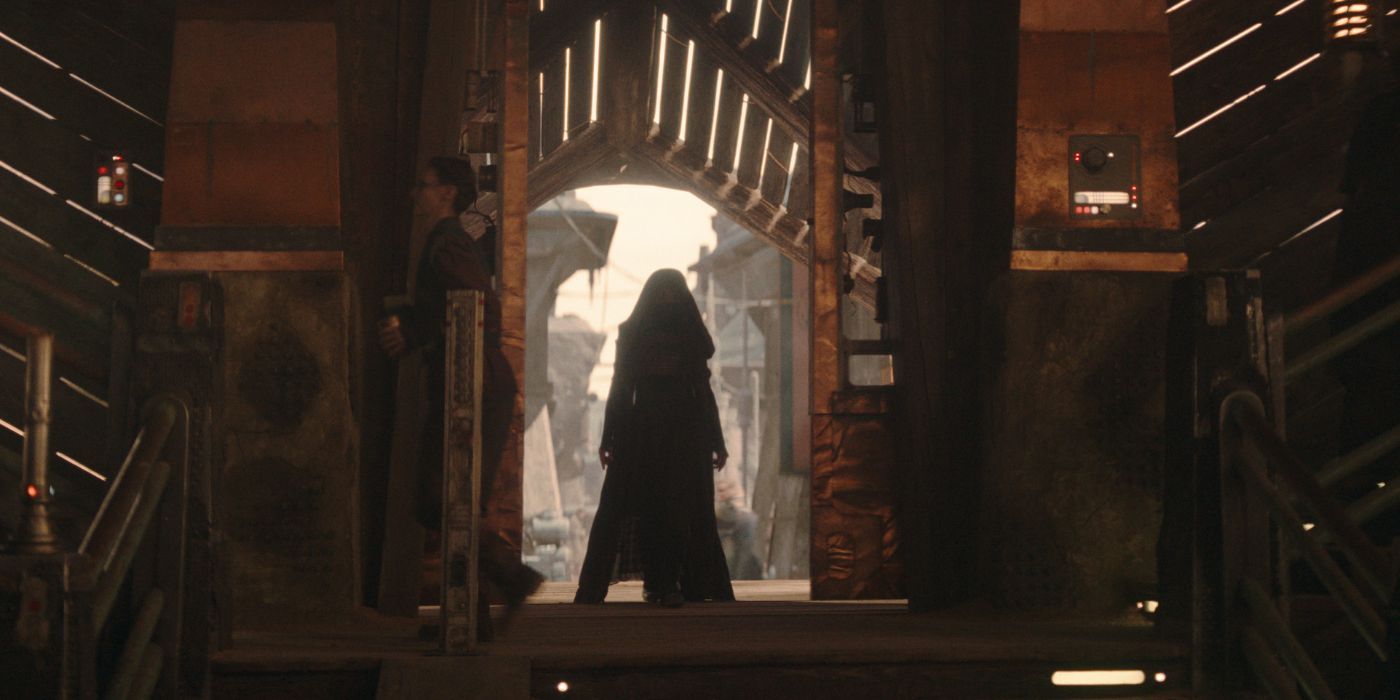 Amandla Stenberg, wearing a robe, while standing in a doorway, in The Acolyte.