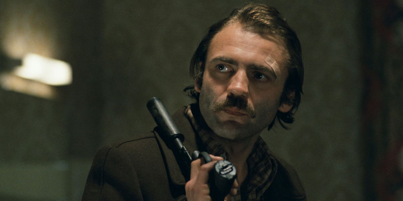 Jonathan Zimmermann (Bruno Ganz) holds a pistol over his shoulder in 'The American Friend' (1977)