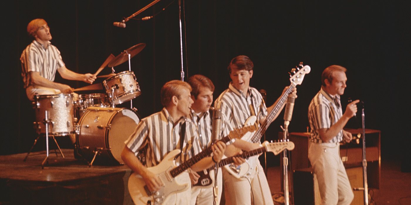 The Beach Boys performing on stage in striped shirts.