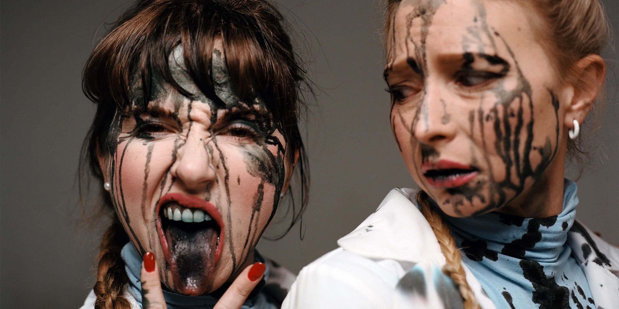 Natalie Palamides and Courtney Pauroso covered in black paint posing for a photo