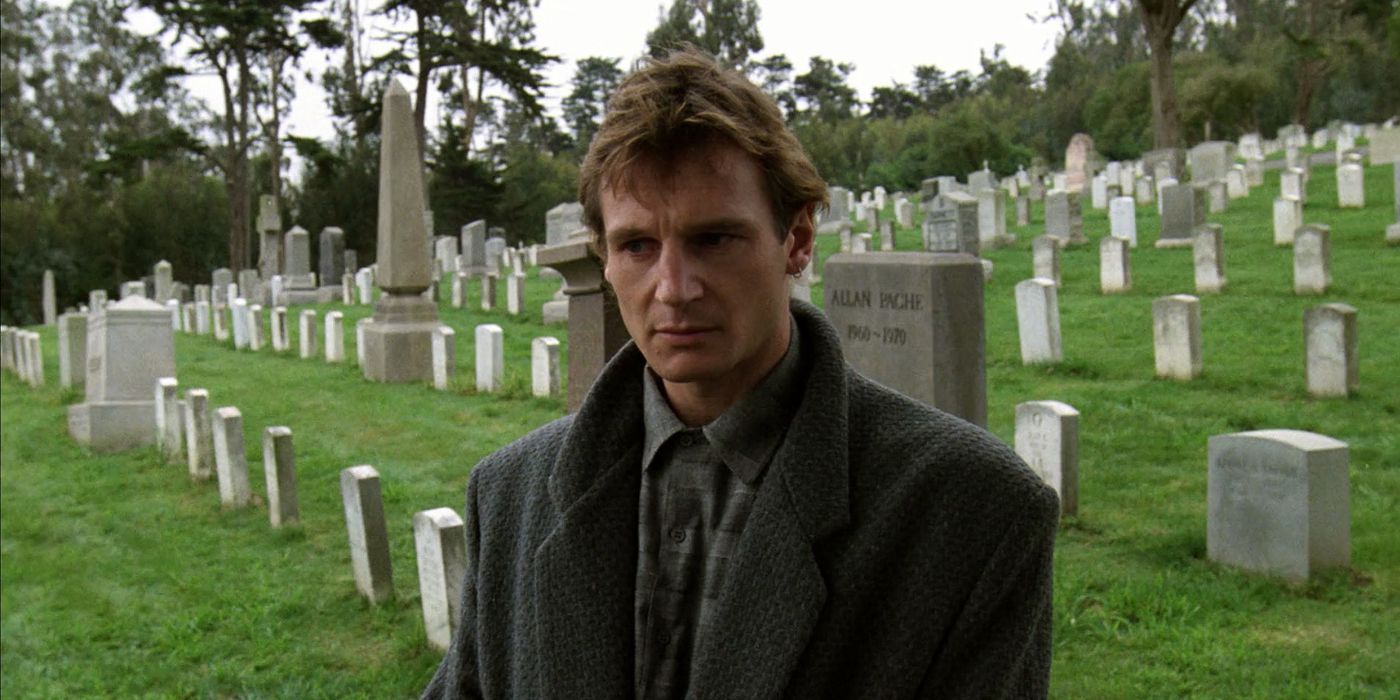 Liam Neeson standing in a graveyard in The Dead Pool