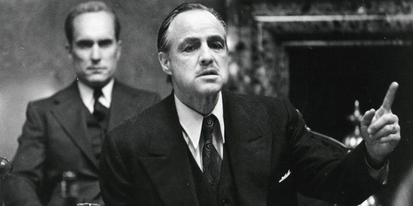 Marlon Brando as Vito Corleone and Robert Duvall as Tom Hagen talking to associates in The Godfather