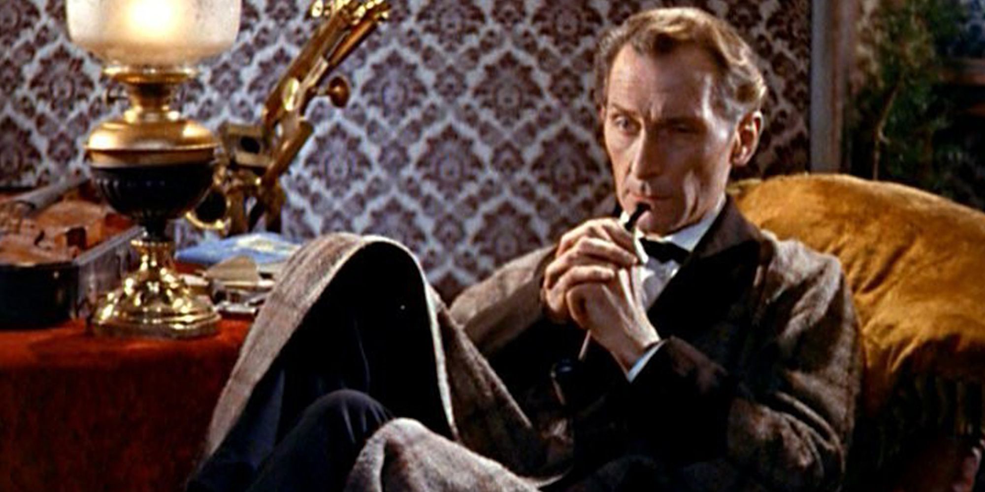 Peter Cushing as Sherlock Holmes sitting and looking pensive in The Hound of the Baskervilles.