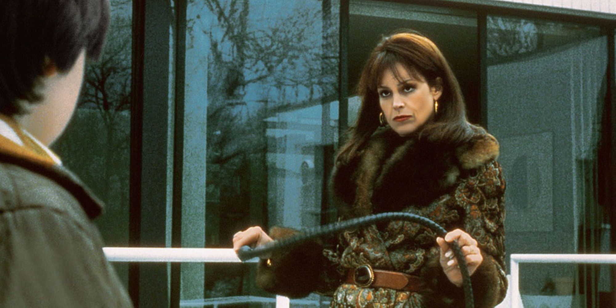 Janey Carvey holding a whip and looking at someone in The Ice Storm - 1997