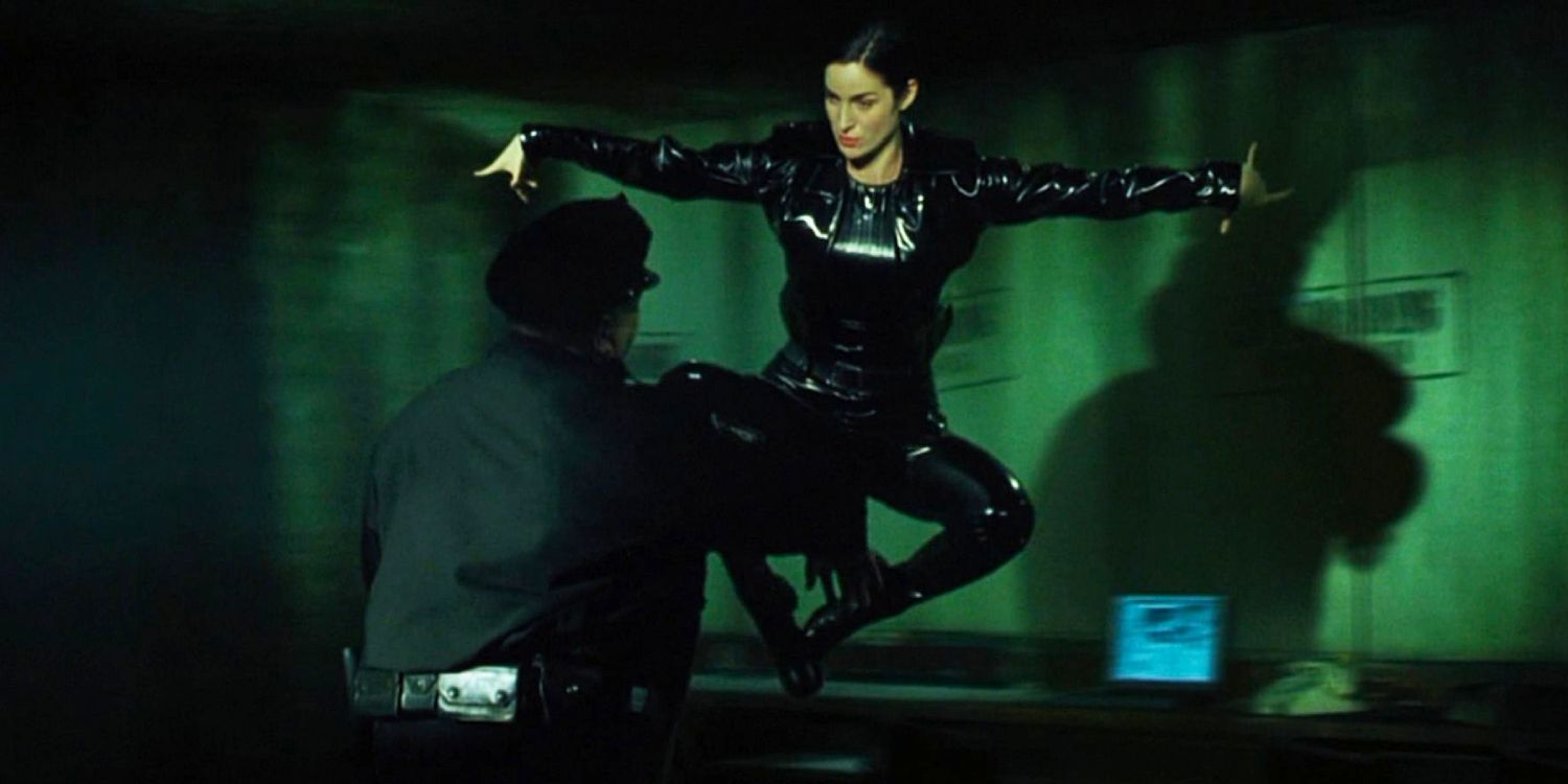 Carrie Anne Moss as Trinity fighting with a police officer in The Matrix