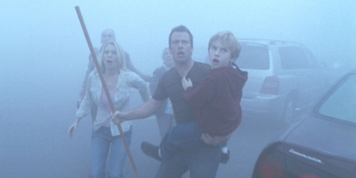 Laurie Holden, Thomas Jane, and Nathan Gamble looking terrified, outside surrounded by mist in 'The Mist'