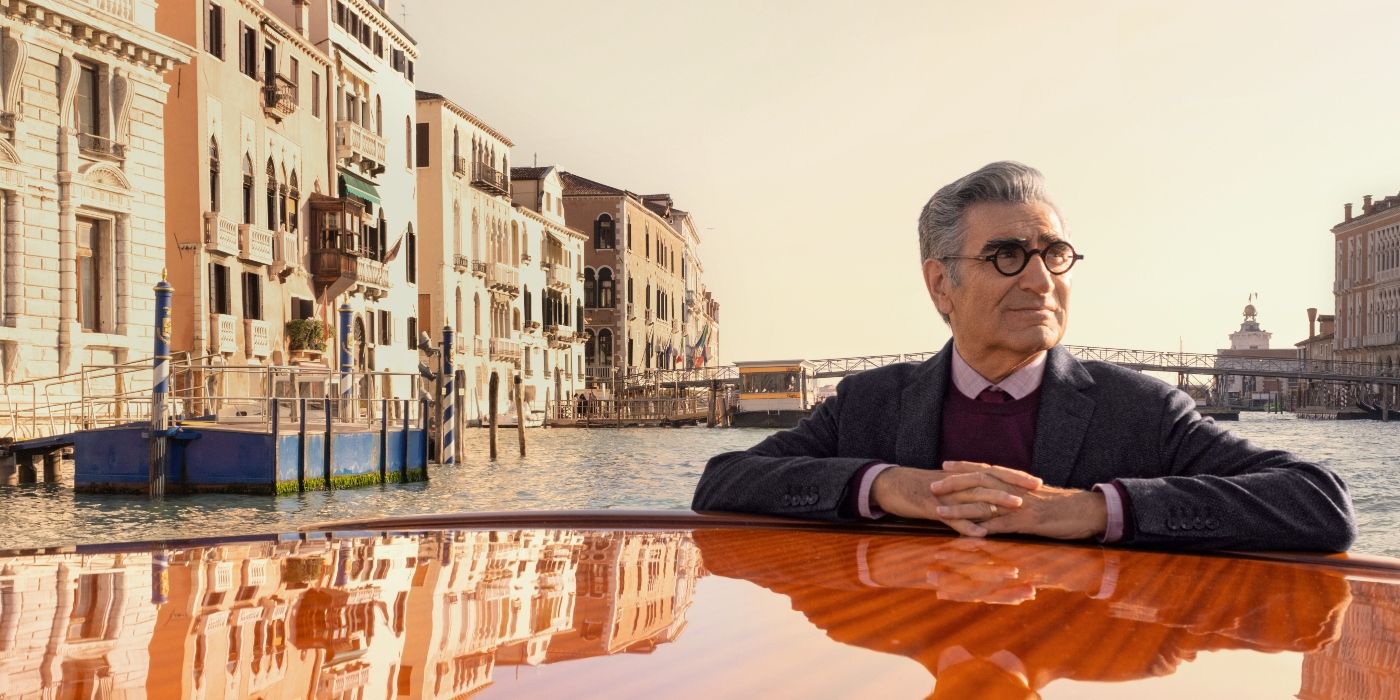 Eugene Levy riding a boat in a river and smiling at sunset in The Reluctant Traveler Season 2