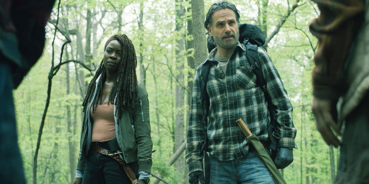 Andrew Lincoln as Rick and Danai Gurira as Michonne stare off camera in the forest in The Walking Dead: The Ones Who Live 