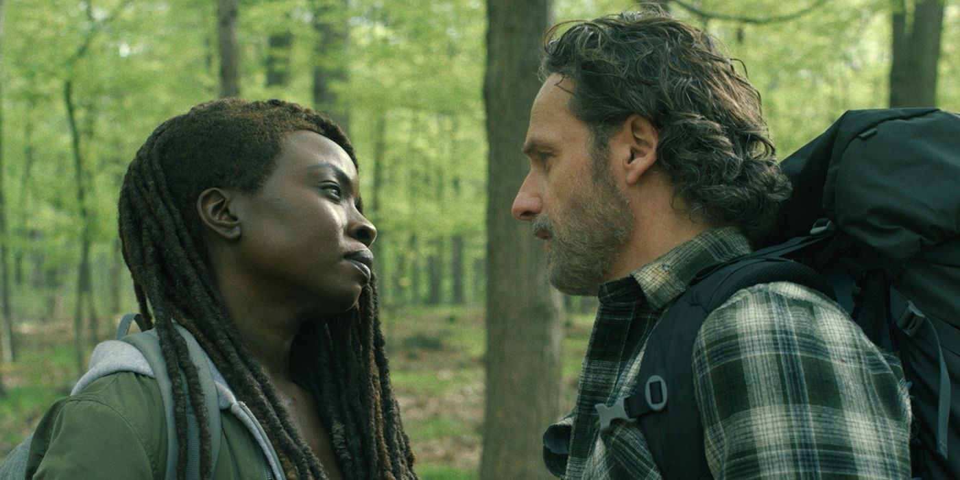 Andrew Lincoln as Rick and Danai Gurira as Michonne stare at each other in the forest in The Walking Dead: The Ones Who Live 