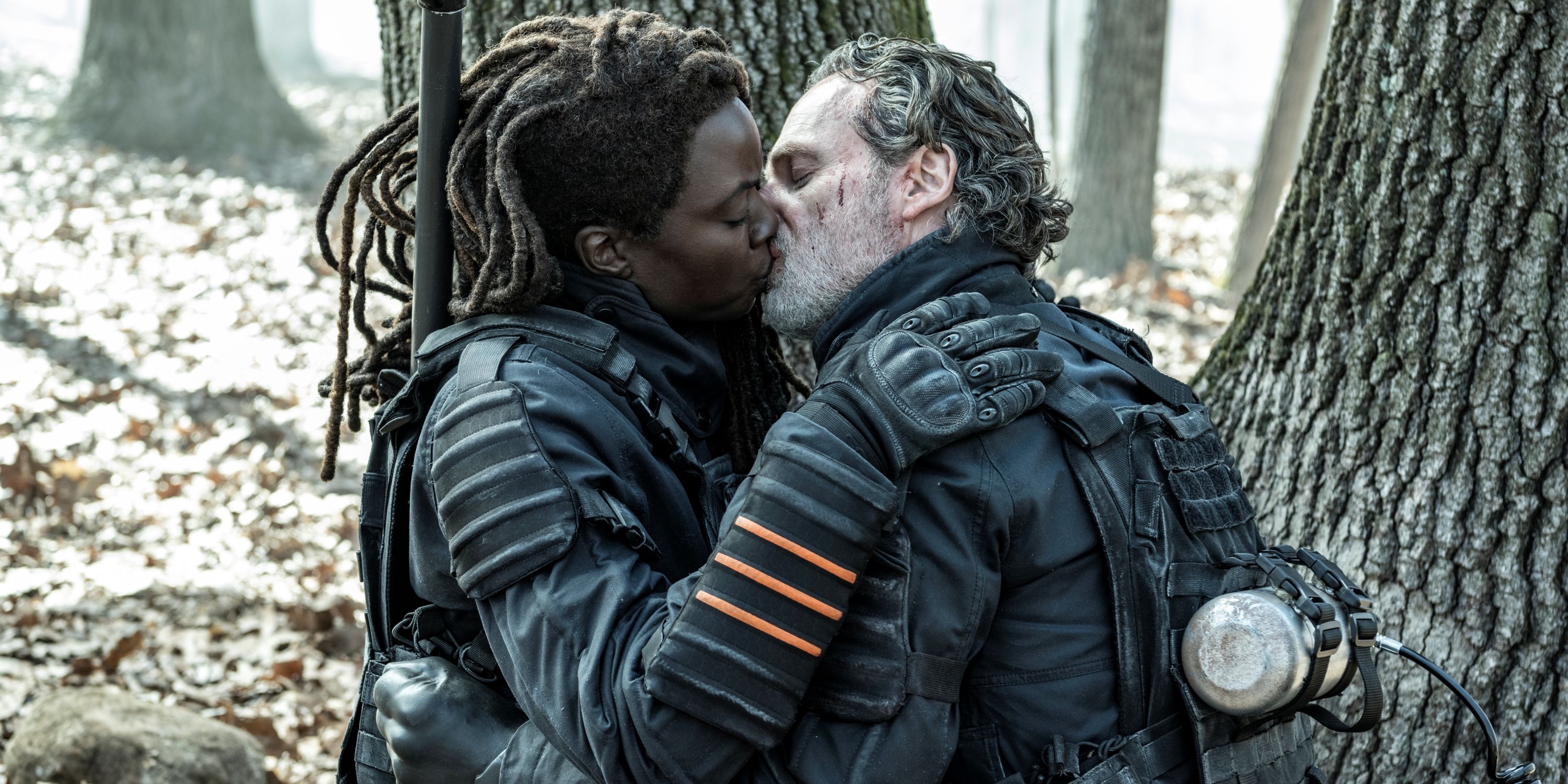 Andrew Lincoln as Rick Grimes and Danai Gurira as Michonne kissing in the forest 