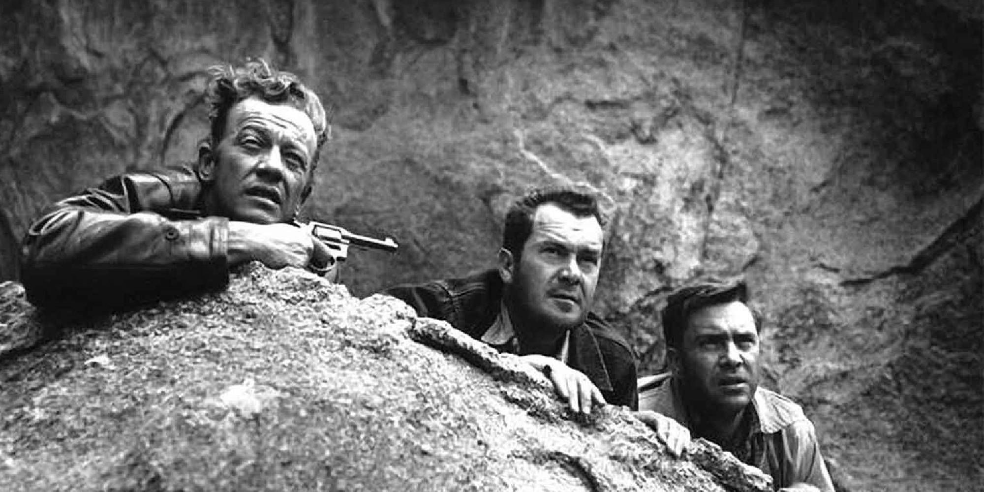 Three men hiding behind a rock in The Hitch-Hiker