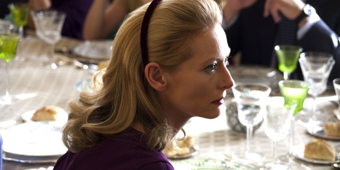 Emma Recchi at a dinner table looking to her right in I Am Love 2009