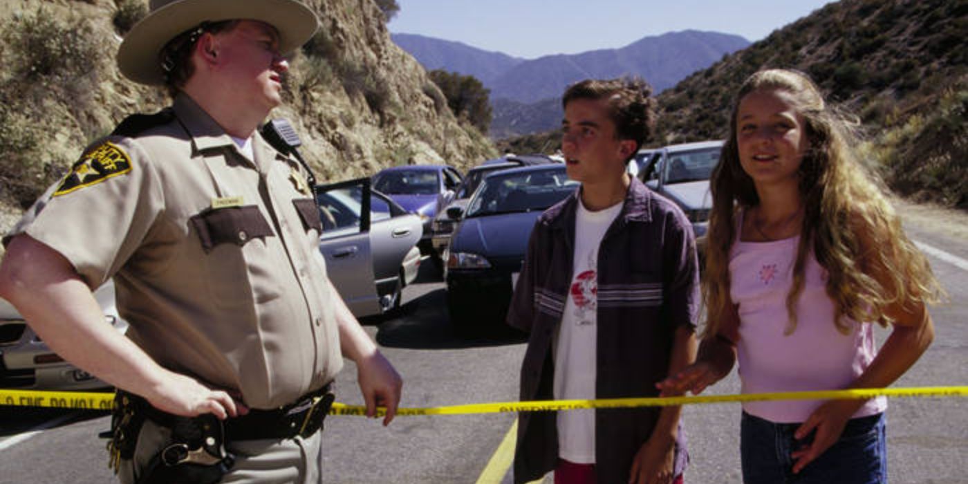 Malcolm and Jessica speak to a policeman over a police line