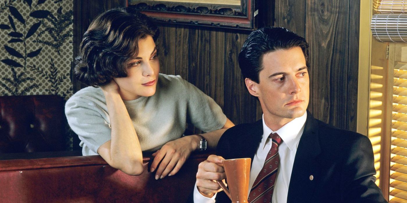 Audrey Horne (Sherilyn Fenn) looking at Dale Cooper (Kyle MacLachlan) while he looks out a window in Twin Peaks