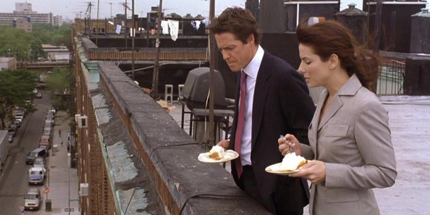 George and Lucy eating cake on a roof in Two Weeks Notice