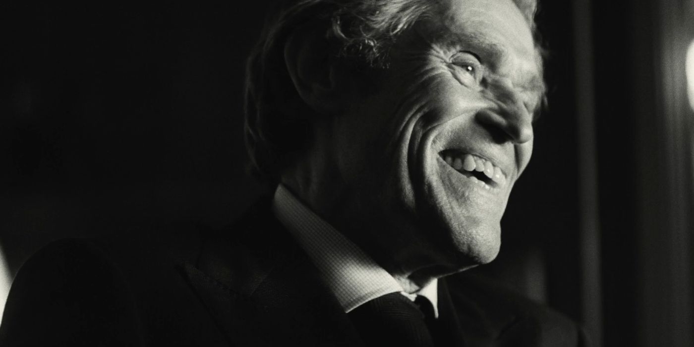 Willem Dafoe laughing in a black and white frame from Kinds of Kindness.