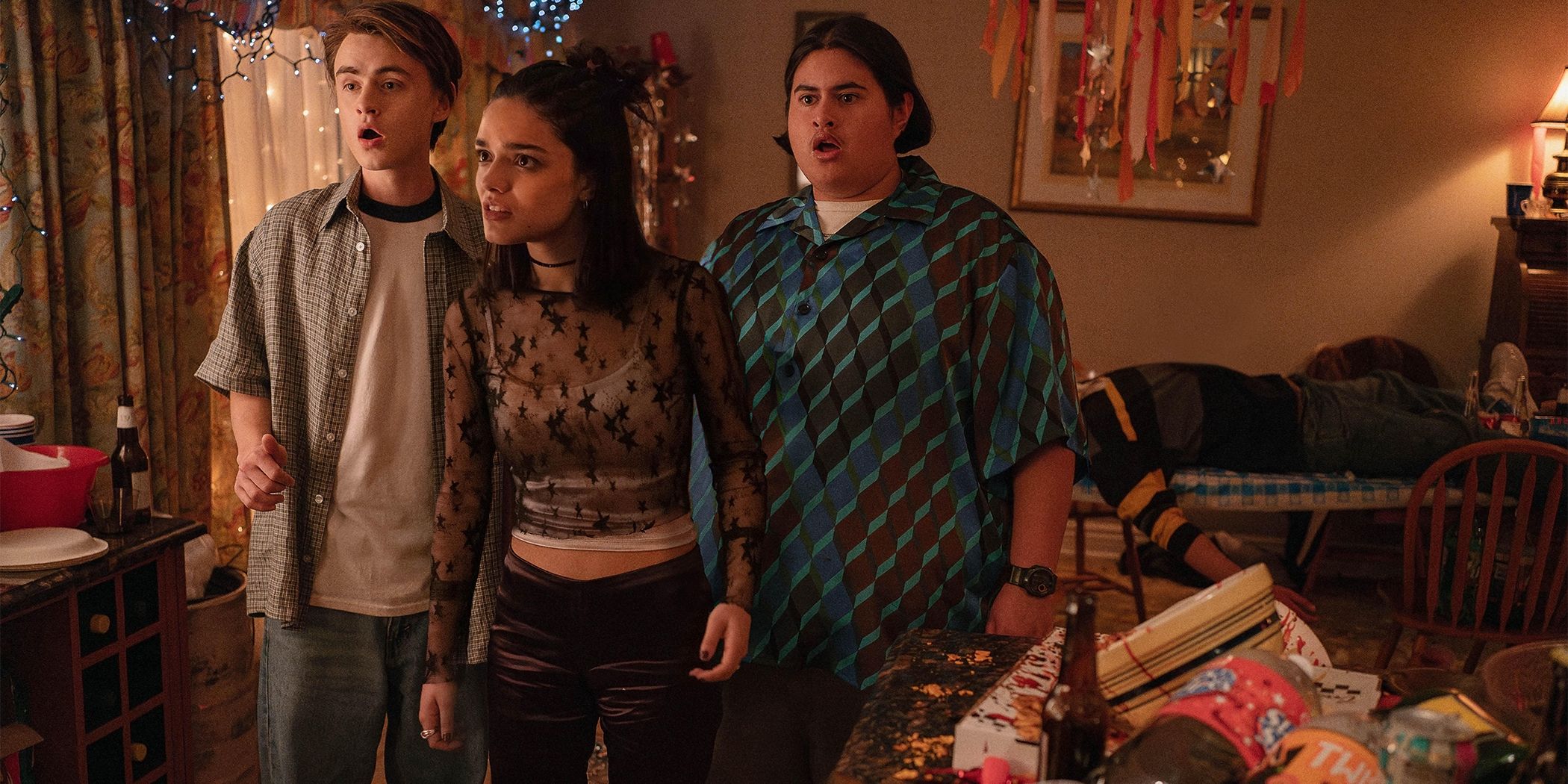 Jaeden Martell, Rachel Zegler and Julian Dennison looking shocked in a room surrounded by party clutter