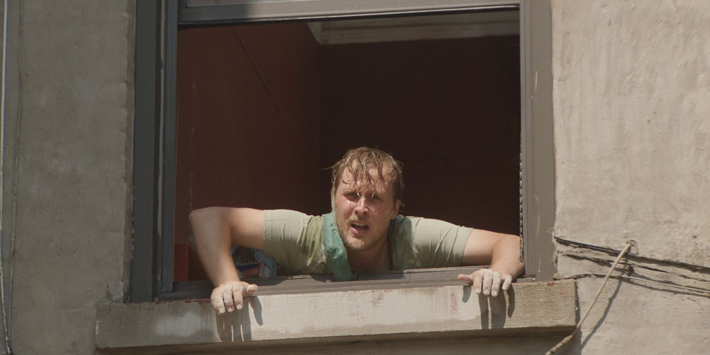 John Early as Terry Goon looking out a window while very sweaty in Stress Positions. 