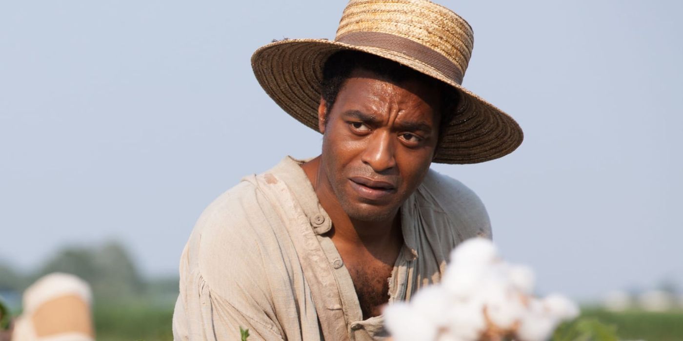 Solomon wears a straw hat as his picks cotton in the field in 12 Years a Slave