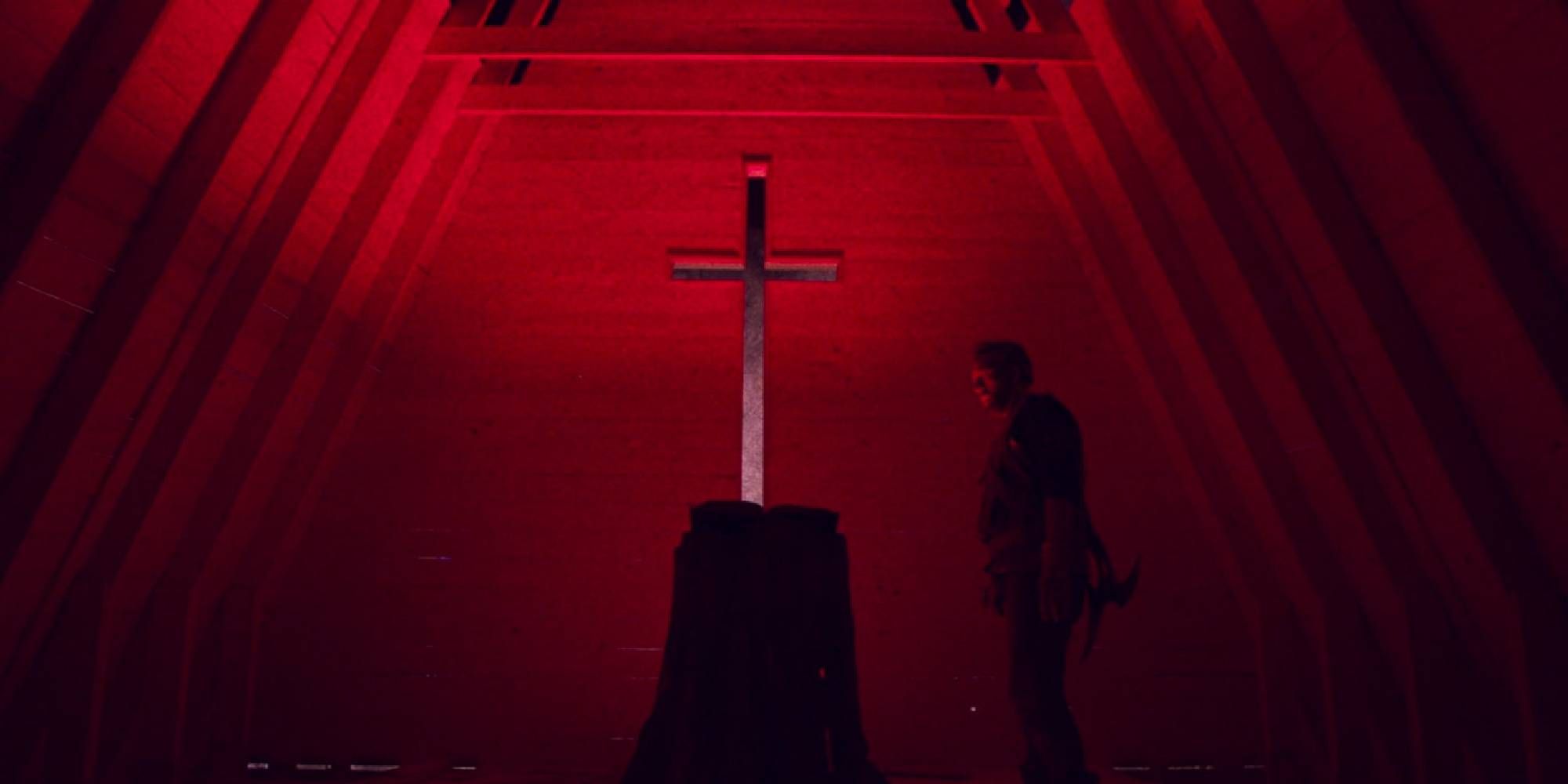 A man stands beside a cross in Mandy.