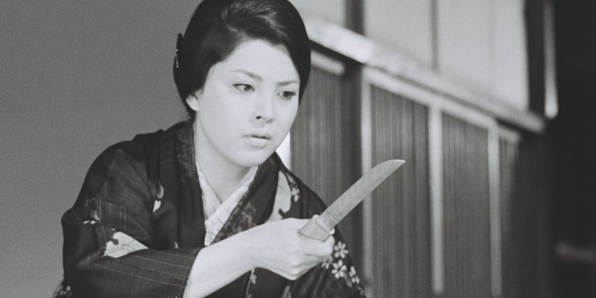 A woman holding a dagger in Eros + Massacre
