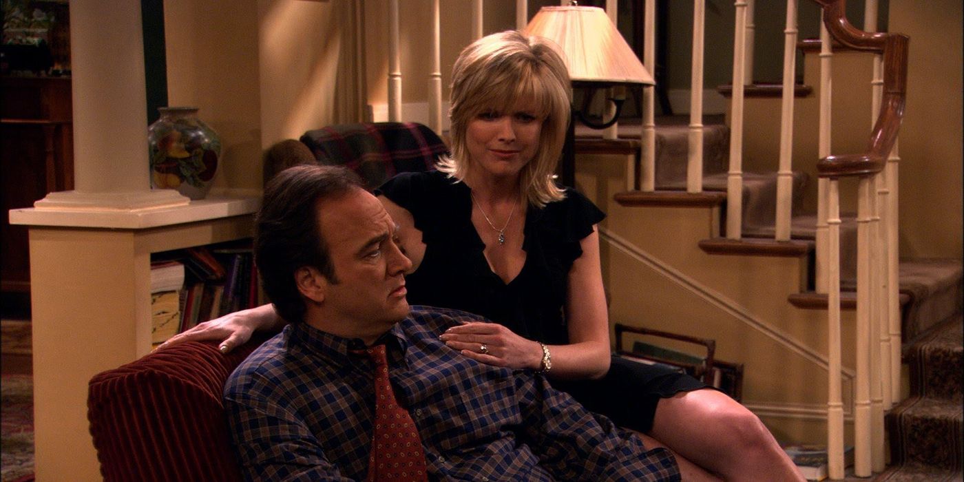 A man sitting in a living room chair, a woman on the side arms around him in According to Jim.