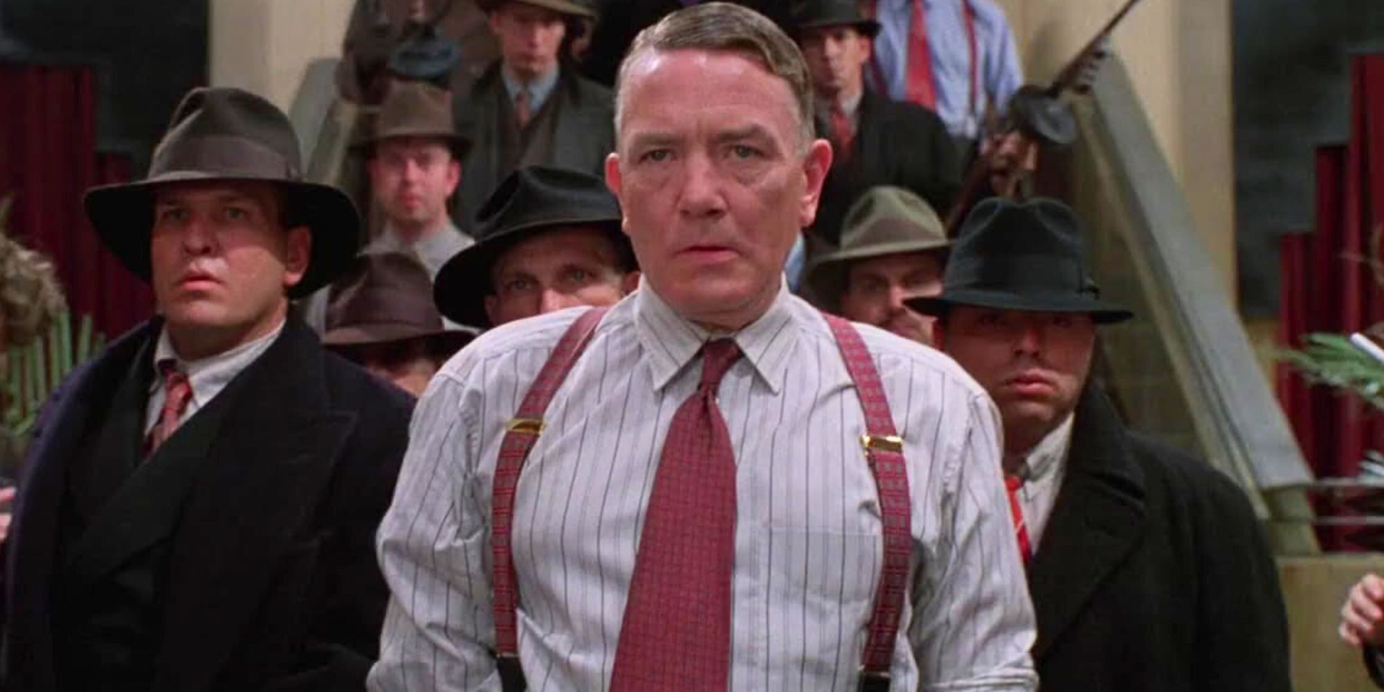 Albert Finney as Leo O'Bannon standing in front of a group of men in Miller's Crossing (1990)