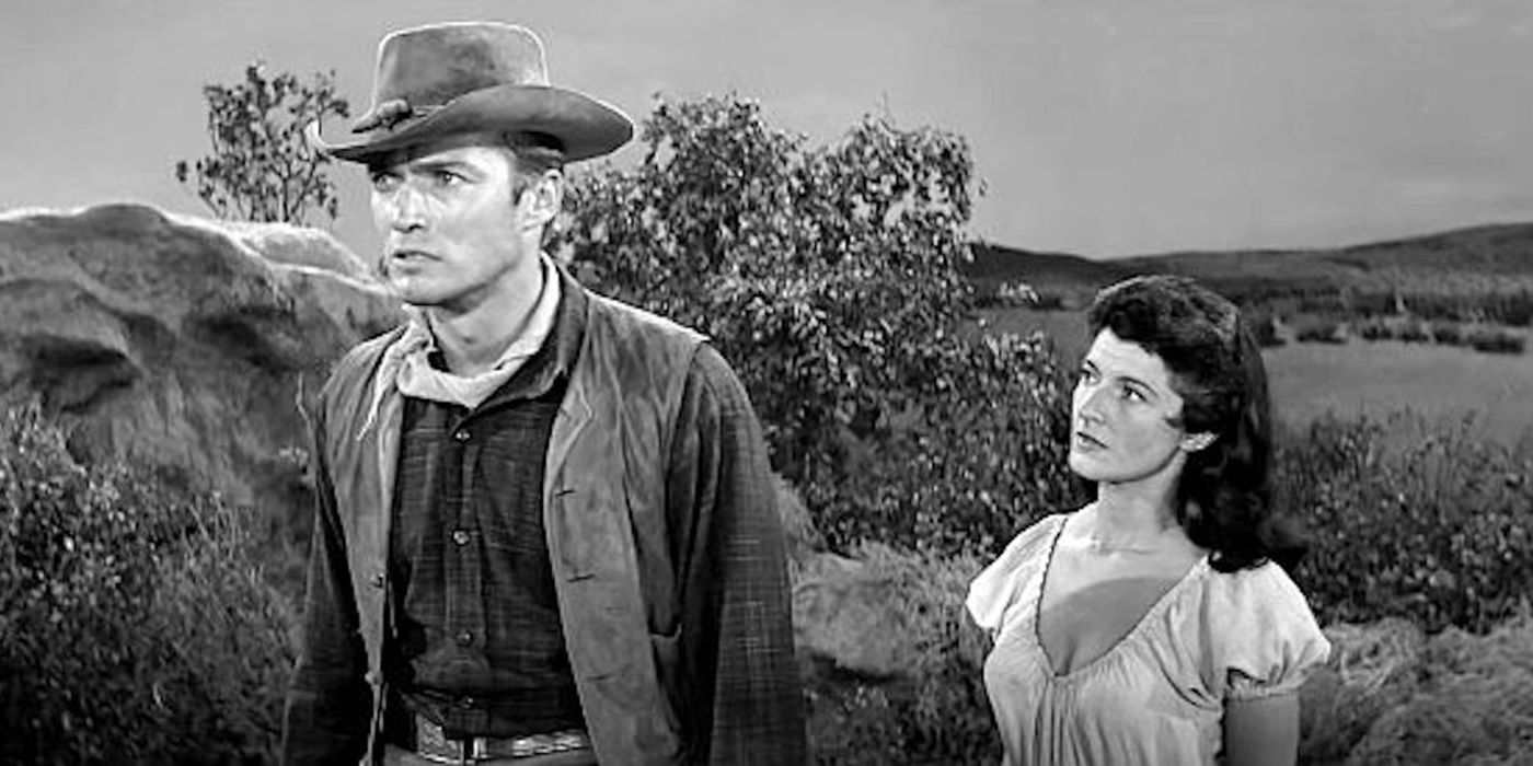 Clint Eastwood as Keith Williams and Margia Dean as Teresa Santos walking together in Ambush at Cimarron Pass