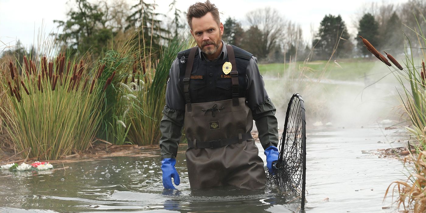Joel McHale walks through a swamp in a scene from Animal Control Season 2