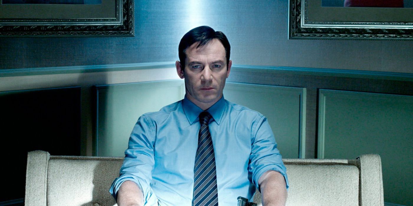 Detective Michael Britten (Jason Isaacs) sits on the couch in the light of the television in 'Awake' (2012)