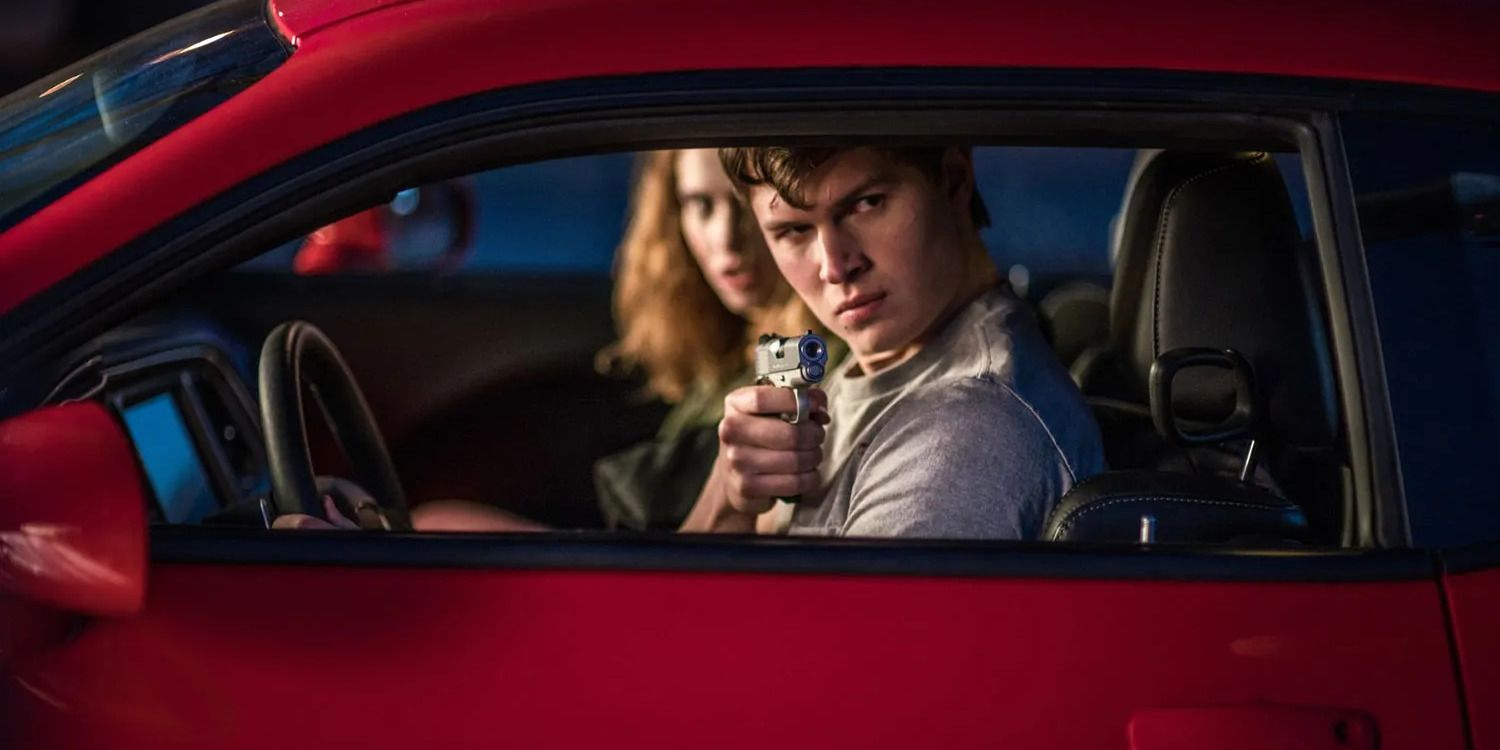 Lily James sits in the passenger seat of a red car while Ansel Elgort points a gun out of the driver&rsquo;s seat window in Edgar Wright&rsquo;s &lsquo;Baby Driver&rsquo;