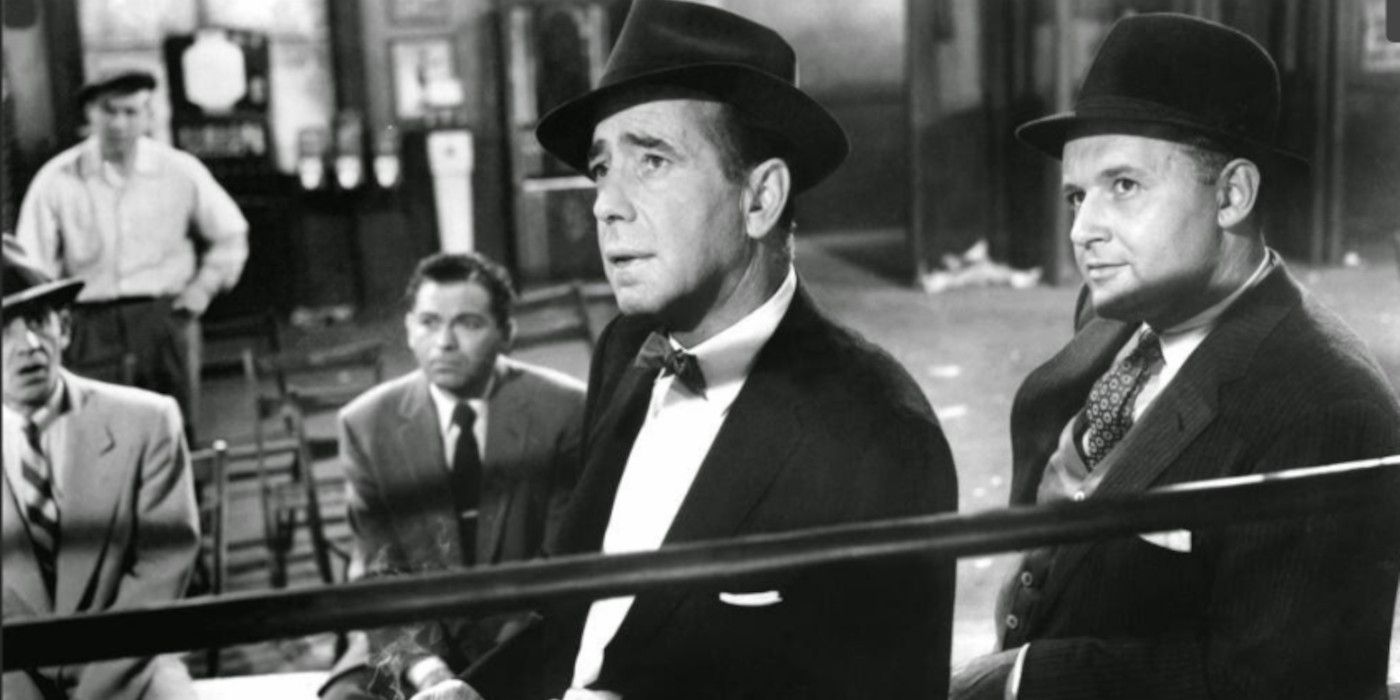 Humphrey Bogart as Eddie Willis watching a person offscreen in 'The Harder They Fall'