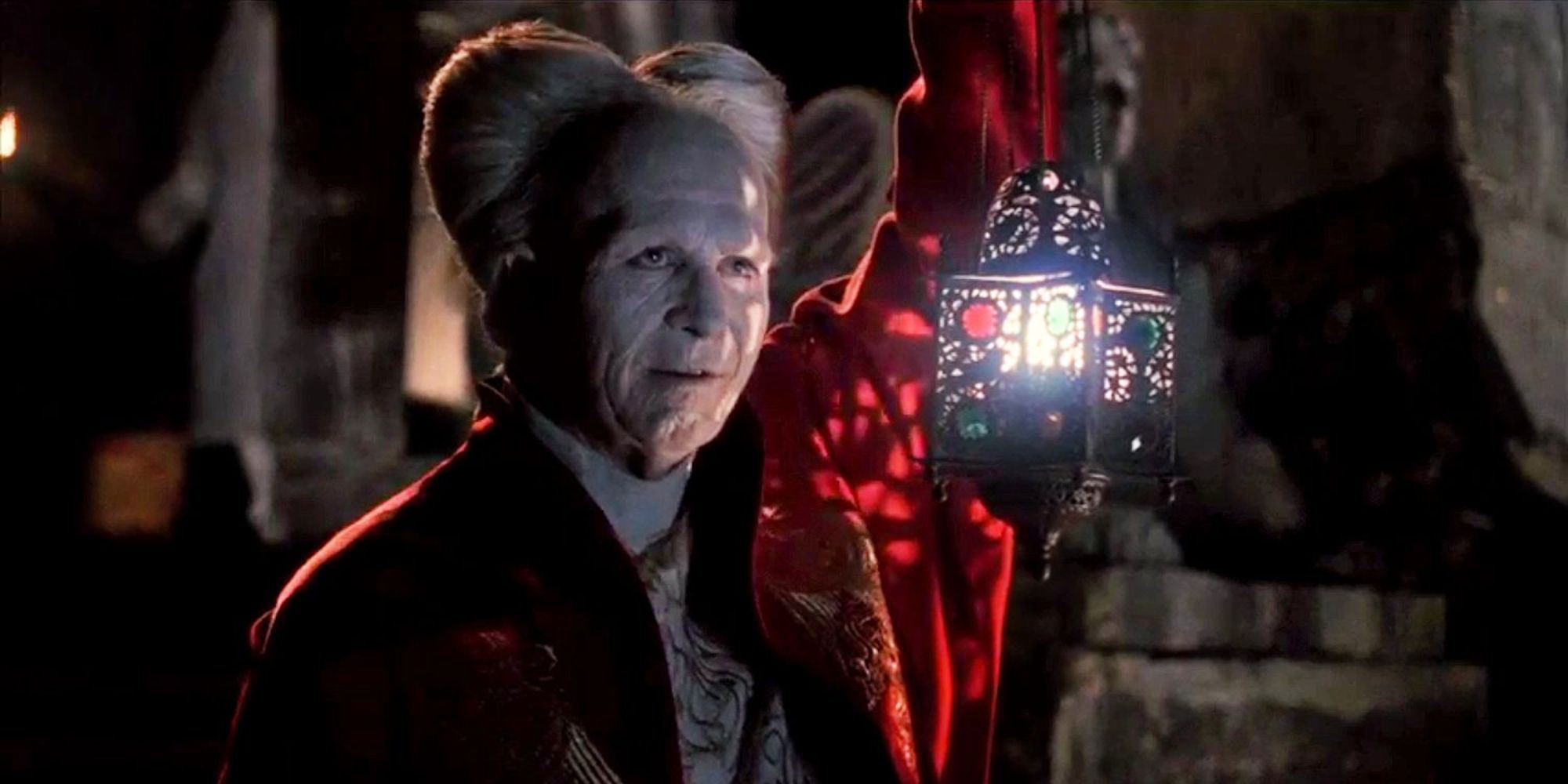 Dracula smiling while holding a lamp in Bram Stoker's Dracula
